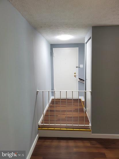 stairway with wood-type flooring and a textured ceiling