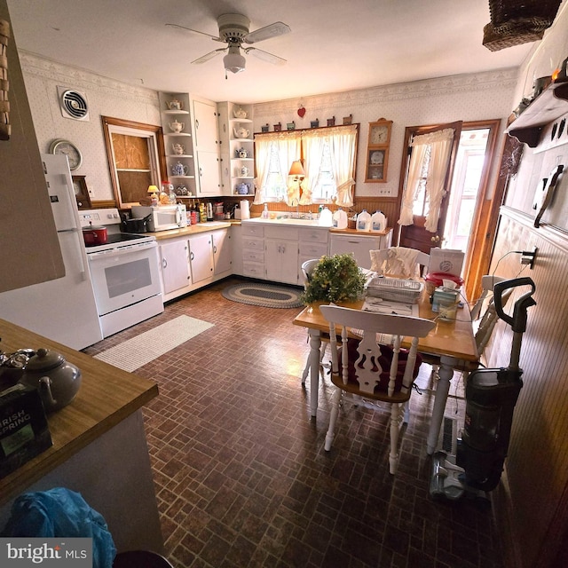 kitchen with white appliances, ceiling fan, and white cabinetry