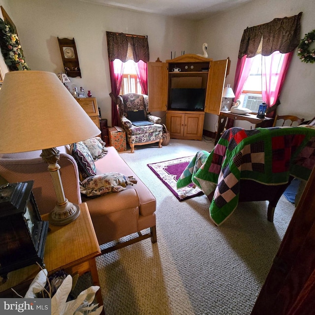 living area with cooling unit and light colored carpet