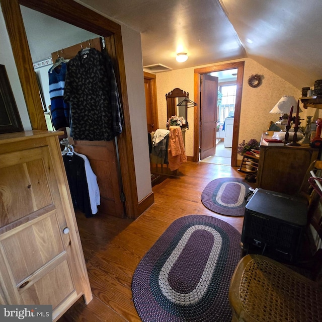 interior space with lofted ceiling, wood finished floors, visible vents, and baseboards