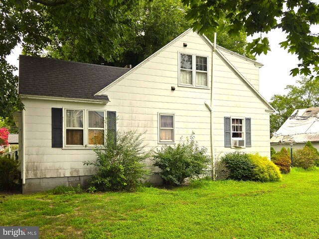 back of property featuring a lawn and cooling unit