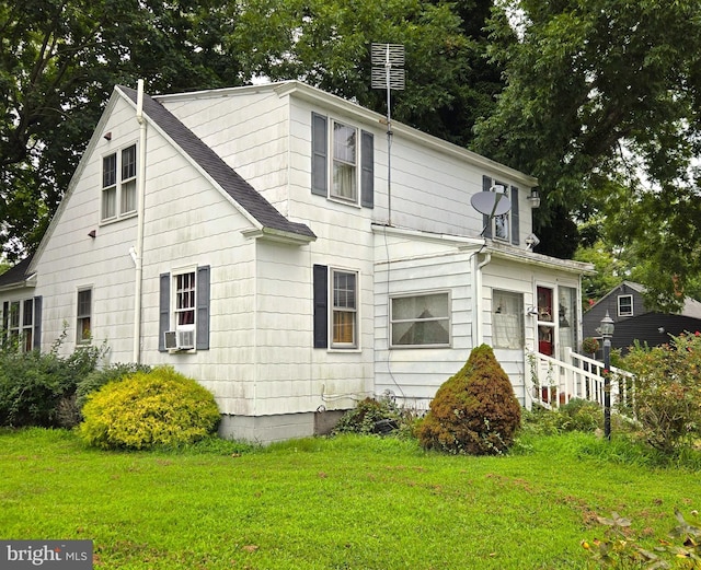 exterior space featuring cooling unit, a lawn, and roof with shingles