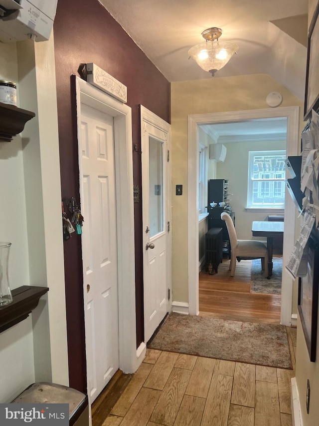 corridor featuring a wall unit AC and light hardwood / wood-style floors