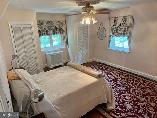 bedroom with ceiling fan, multiple closets, and radiator