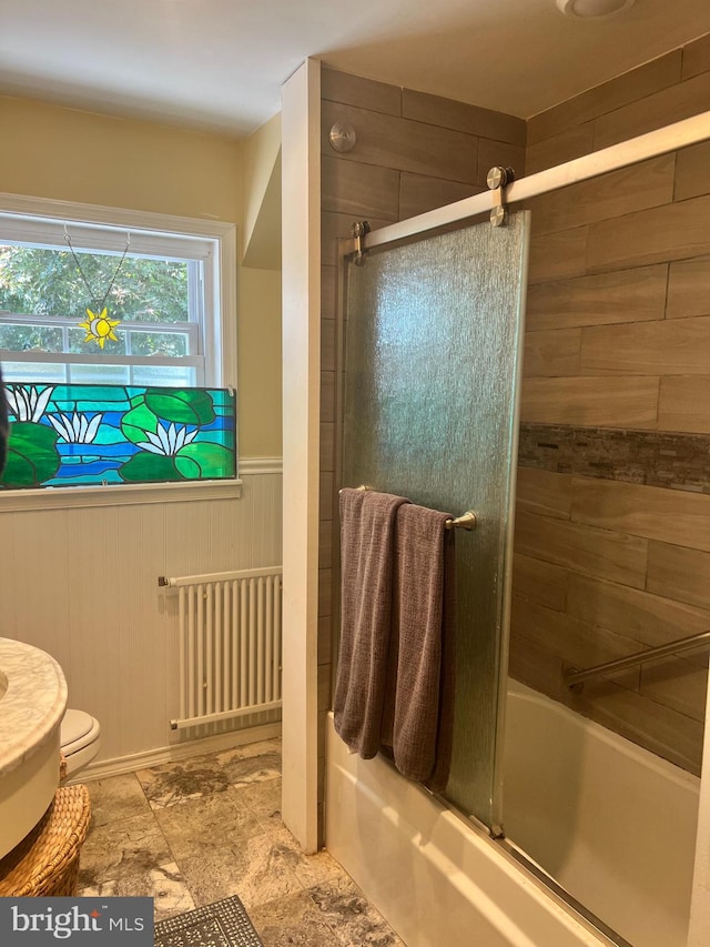 bathroom with radiator, combined bath / shower with glass door, toilet, and tile patterned floors