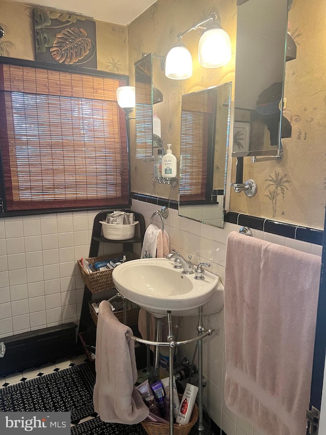 bathroom with backsplash, tile walls, and sink