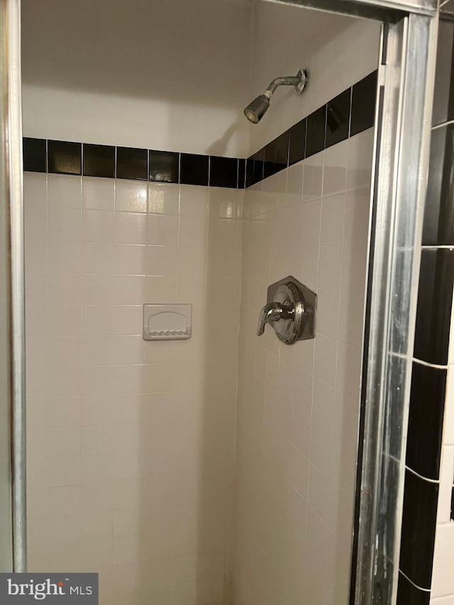 interior details featuring a tile shower