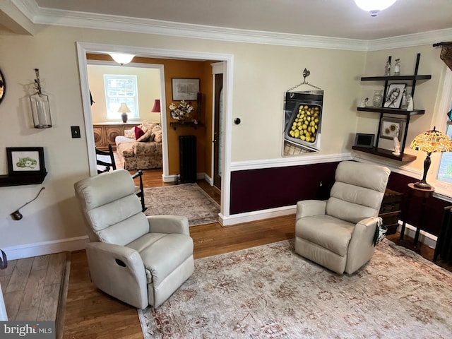 living area with light wood-type flooring and crown molding