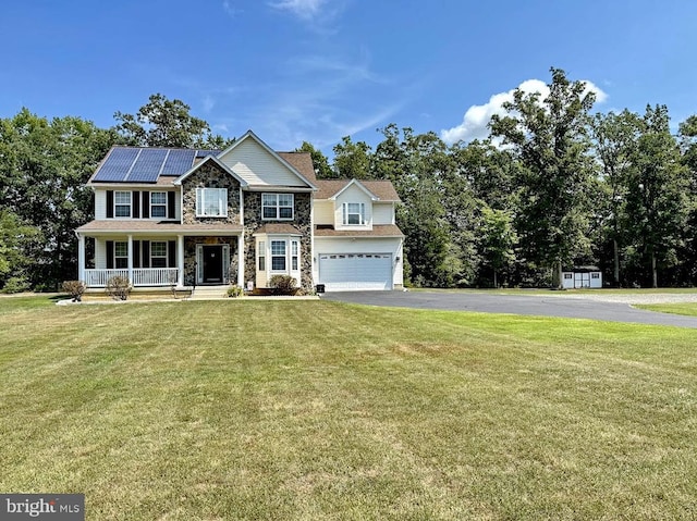 colonial house featuring driveway, stone siding, covered porch, roof mounted solar panels, and a front yard