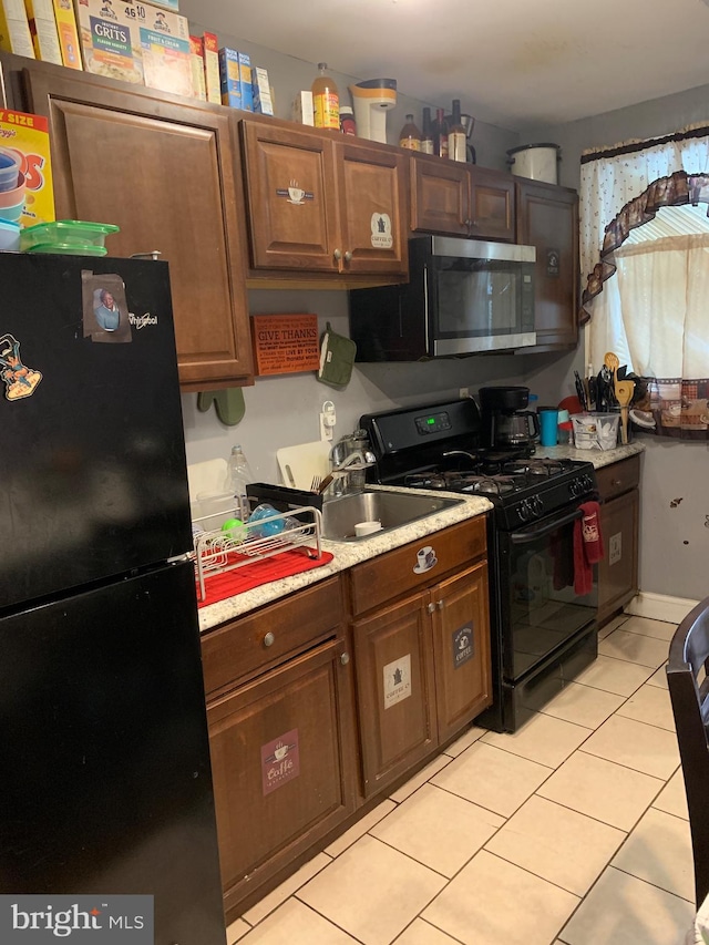 kitchen with black appliances and light tile patterned floors