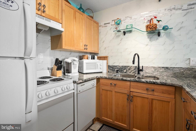 kitchen featuring tile patterned floors, sink, dark stone countertops, a textured ceiling, and white appliances