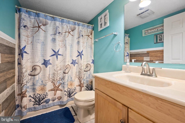 bathroom featuring a shower with shower curtain, vanity, tile patterned floors, a textured ceiling, and toilet