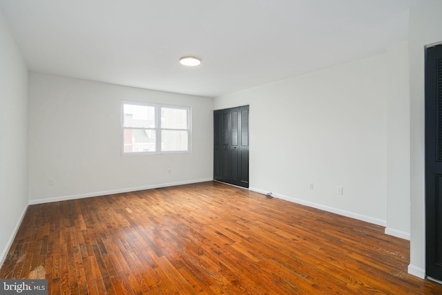 empty room with hardwood / wood-style floors