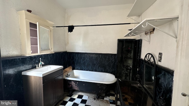 bathroom with tile walls, vanity, and a tub