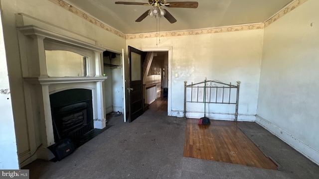 unfurnished living room featuring ceiling fan, dark hardwood / wood-style floors, and a fireplace