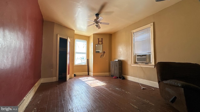 doorway to outside with radiator heating unit, cooling unit, ceiling fan, and dark hardwood / wood-style flooring