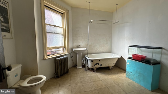 bathroom featuring radiator heating unit, a washtub, and toilet