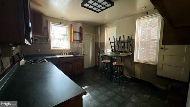 kitchen featuring a breakfast bar, stove, and sink