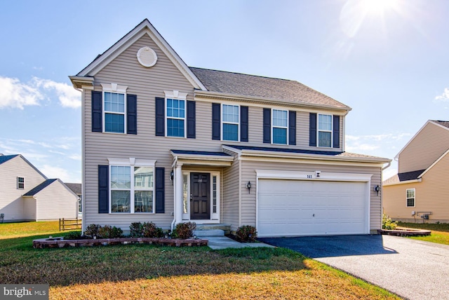 traditional home featuring a garage, a front lawn, and driveway