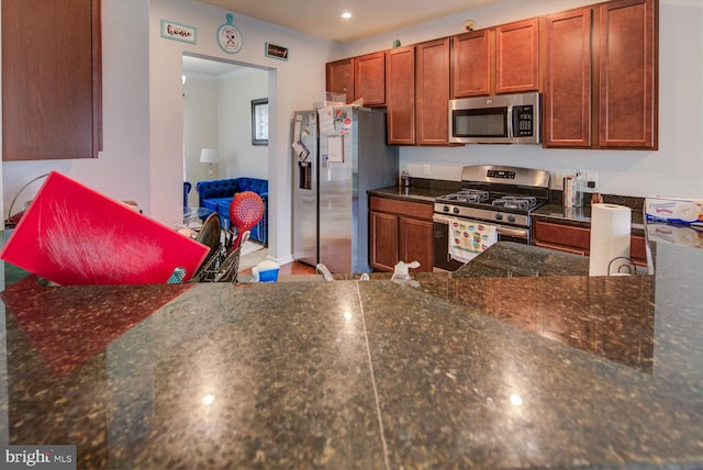 kitchen featuring appliances with stainless steel finishes and dark stone counters