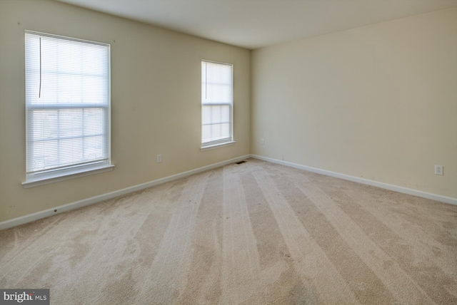 spare room featuring light colored carpet