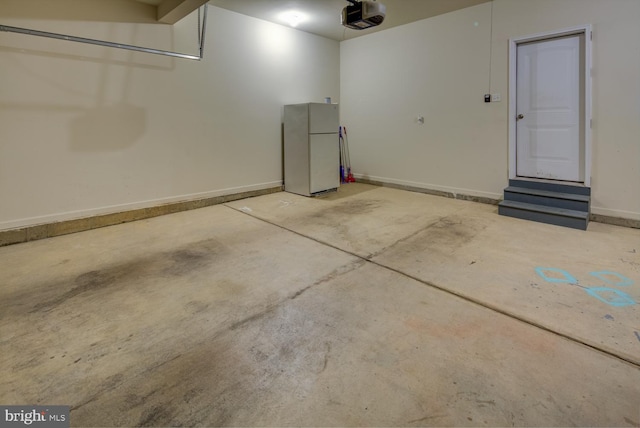 garage featuring a garage door opener and white fridge