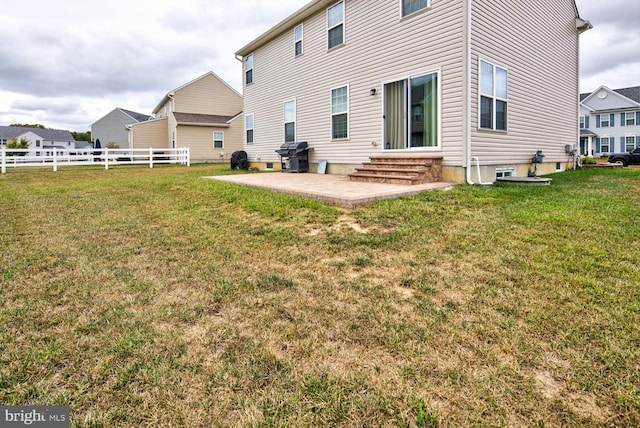 rear view of house with a lawn and a patio