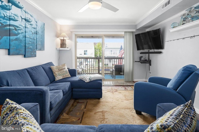 living room featuring ceiling fan, ornamental molding, and carpet