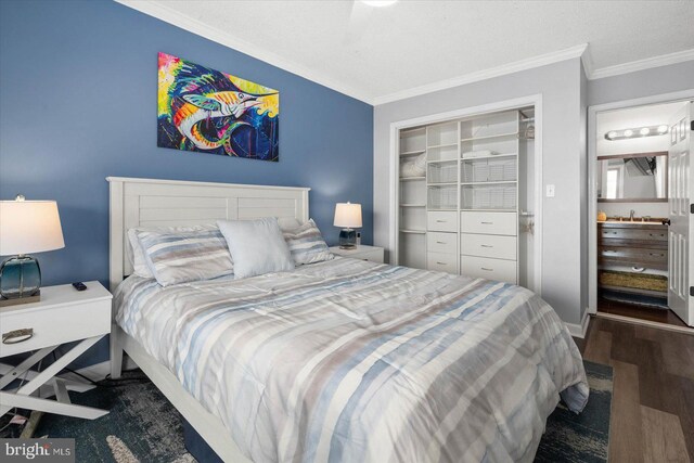 bedroom with ornamental molding, dark hardwood / wood-style flooring, sink, and a closet