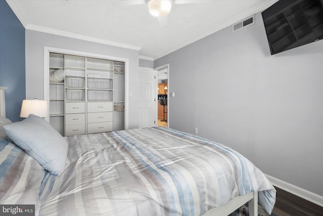 bedroom featuring hardwood / wood-style flooring, ornamental molding, a textured ceiling, and a closet