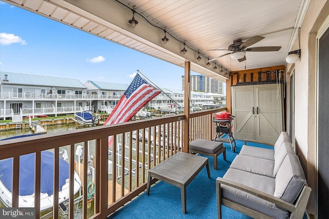 balcony with ceiling fan and a water view