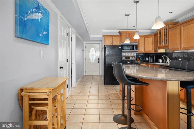 kitchen featuring appliances with stainless steel finishes, light tile patterned floors, backsplash, and a kitchen breakfast bar