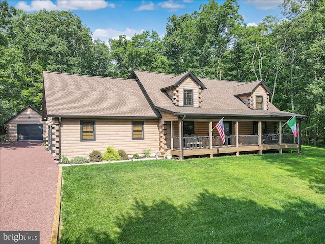 log cabin featuring a garage, an outbuilding, and a front yard