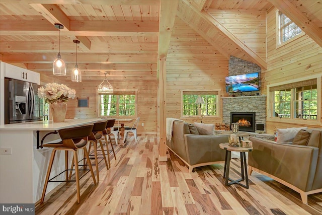 living room with light hardwood / wood-style floors, a wealth of natural light, and wooden walls