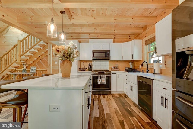 kitchen featuring white cabinetry, wood-type flooring, appliances with stainless steel finishes, and wooden ceiling