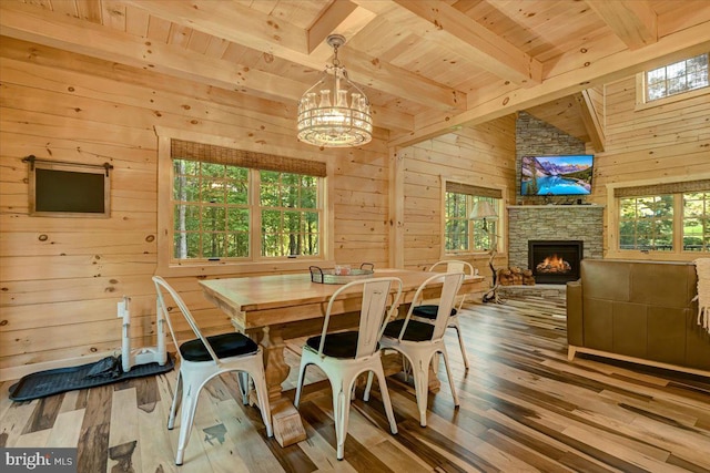 dining space featuring wood walls, a healthy amount of sunlight, and hardwood / wood-style floors