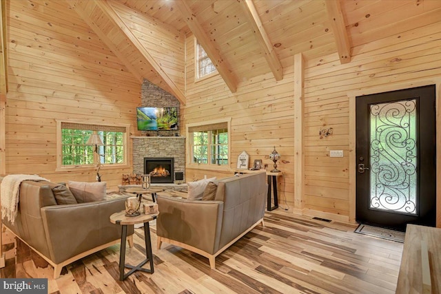 living room with a fireplace, wooden walls, beamed ceiling, light hardwood / wood-style flooring, and wood ceiling