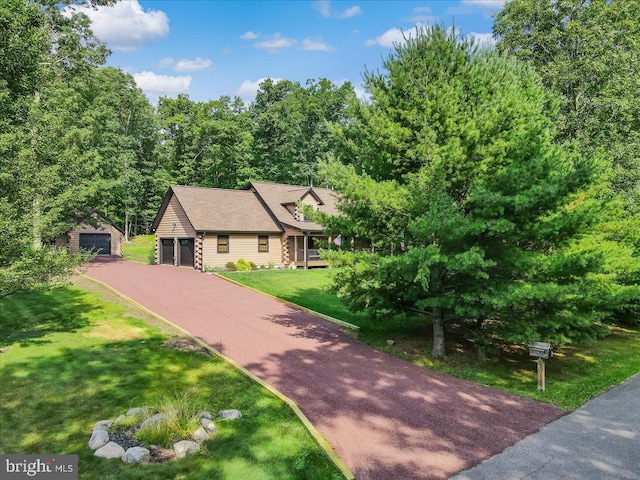 view of front of house featuring an outdoor structure, a garage, and a front lawn