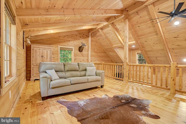 living room with lofted ceiling with beams, light hardwood / wood-style flooring, wood walls, wooden ceiling, and ceiling fan