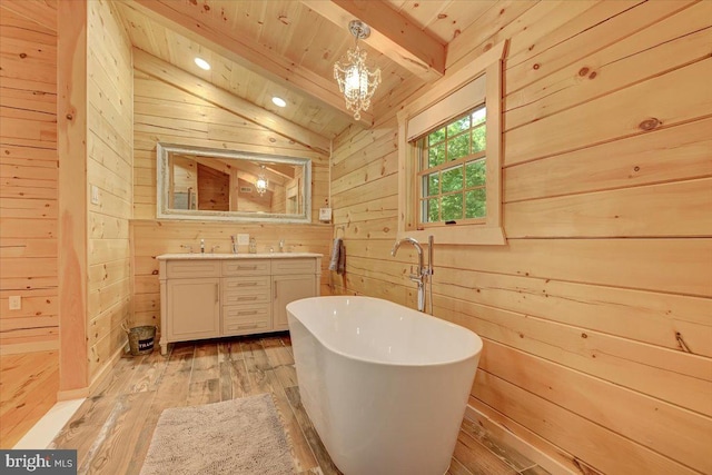 bathroom with wood walls, lofted ceiling with beams, hardwood / wood-style floors, and vanity