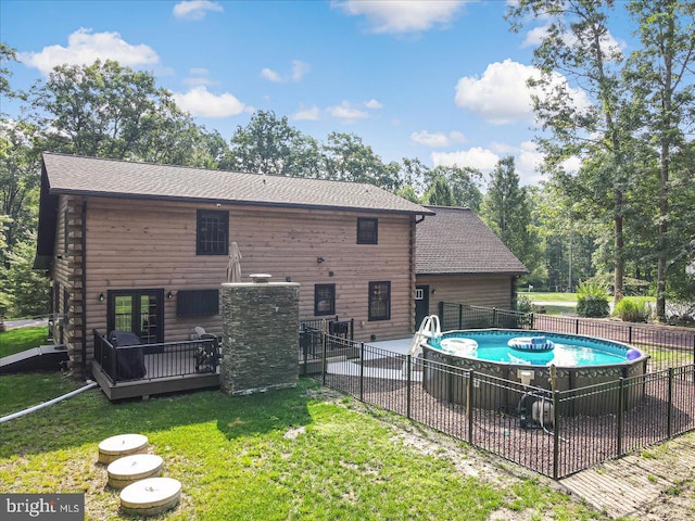 back of house with a pool side deck and a lawn