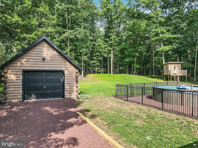 garage featuring a lawn and a covered pool