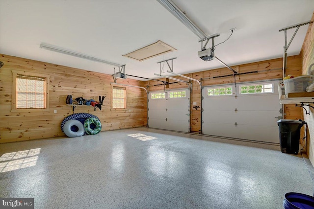 garage featuring a garage door opener and wooden walls