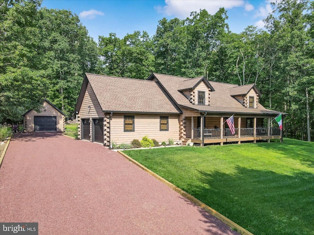 cabin featuring a garage, an outbuilding, and a front yard