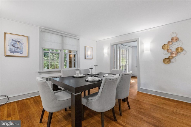 dining room featuring crown molding, wood-type flooring, and radiator