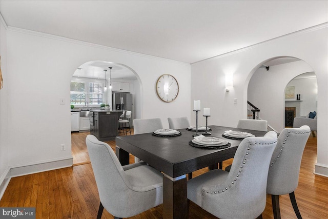 dining room with light hardwood / wood-style flooring and ornamental molding