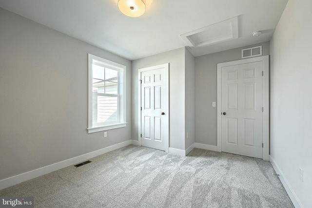 unfurnished bedroom featuring light colored carpet and a closet