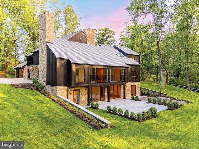 607 W Gravers Ln, Philadelphia, PA 19118 - back of house featuring a chimney, concrete driveway, stone siding, and board and batten siding