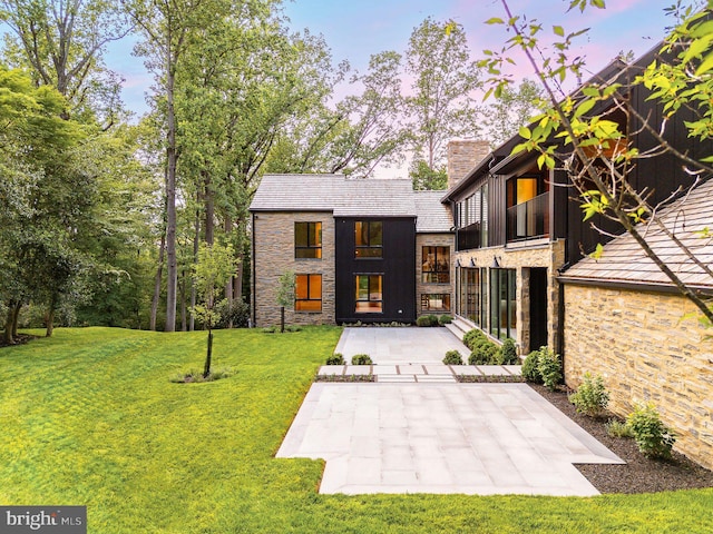 607 W Gravers Ln, Philadelphia, PA 19118 - back of property with stone siding, a chimney, and a yard