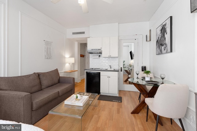 living room with ceiling fan, light hardwood / wood-style flooring, and sink